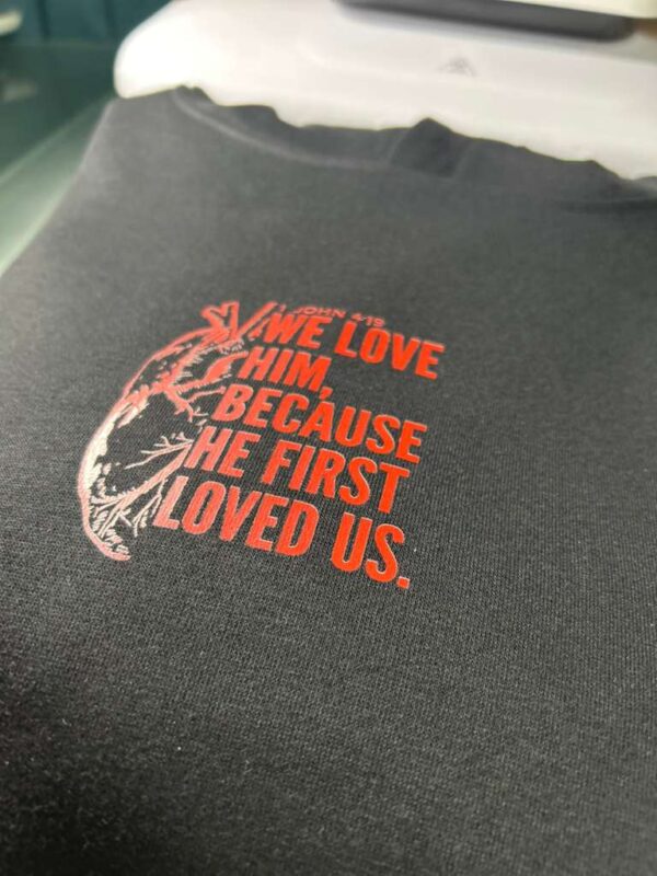 Polerón Canguro “We Love Him” – 1 Juan 4:19